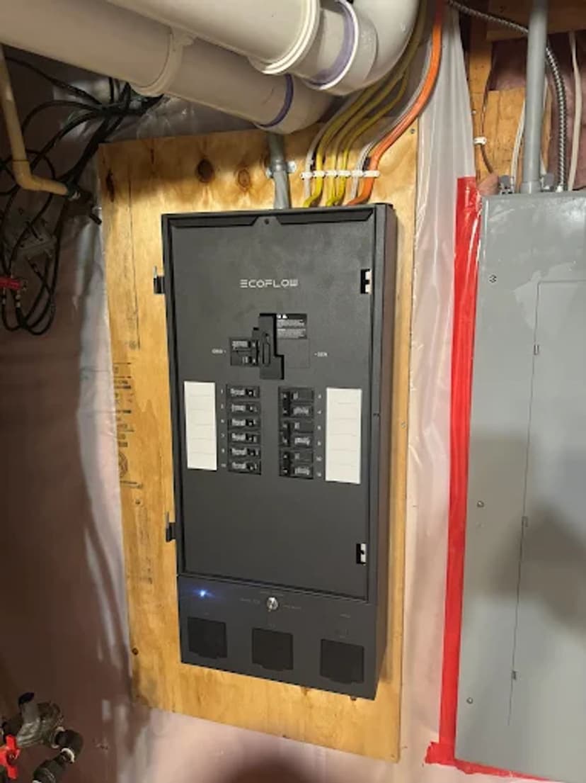 Modern electrical panel installation in a basement, showcasing circuit breakers and connections.